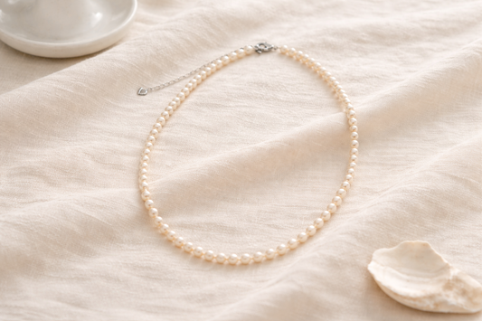 Apricot Glow Pearl Necklace layered over a linen blazer