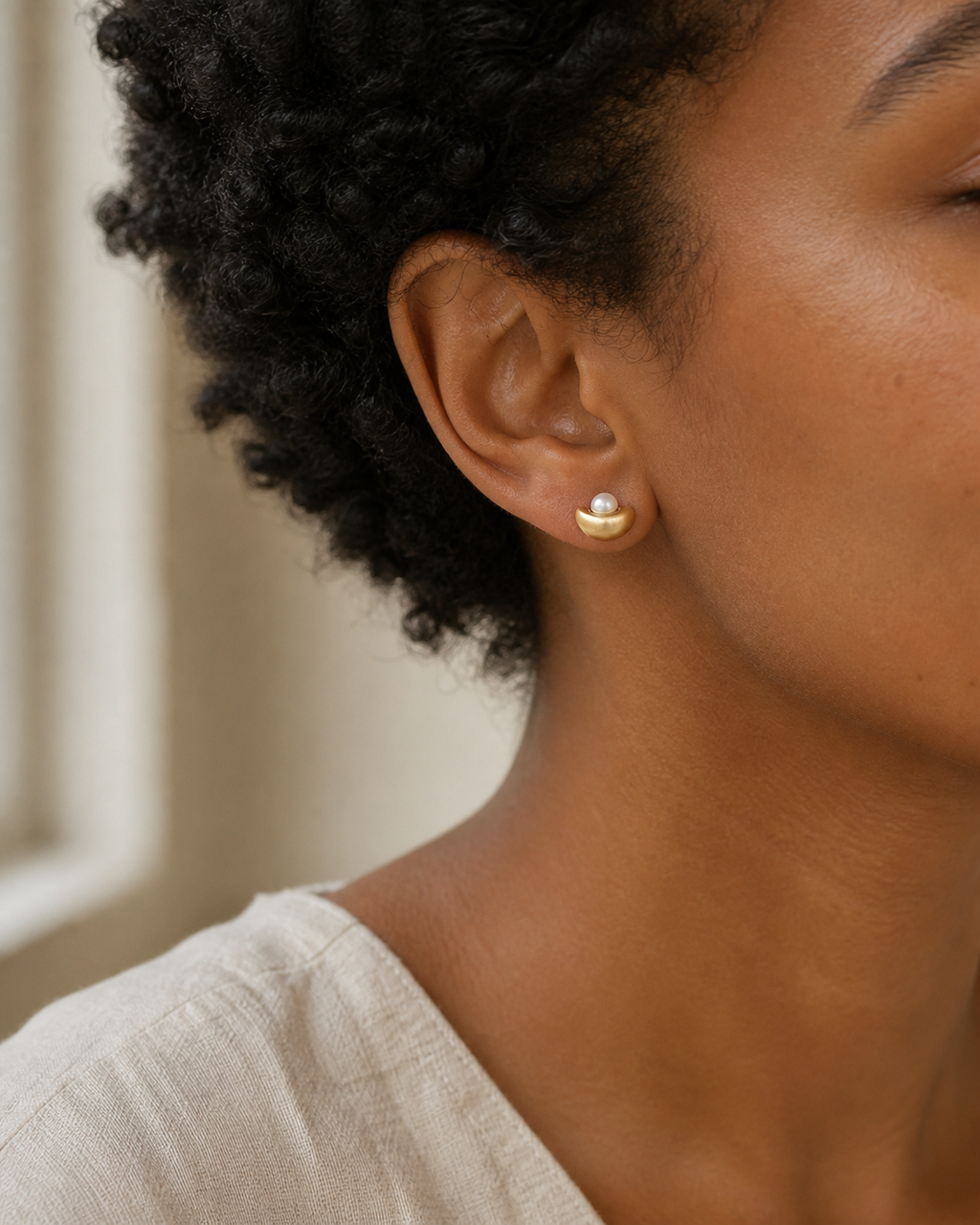 Golden Cradle Petite Pearl Studs — half-moon pearl stud try-on