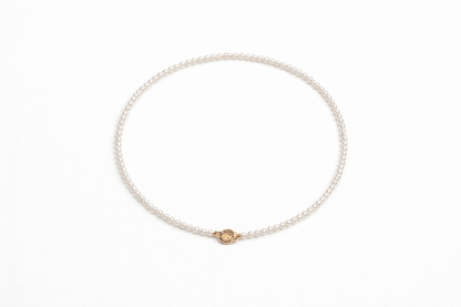 Pearl bracelet with a gold clasp on a white background